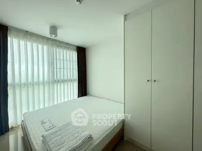 Bright and airy bedroom with large window and built-in wardrobe