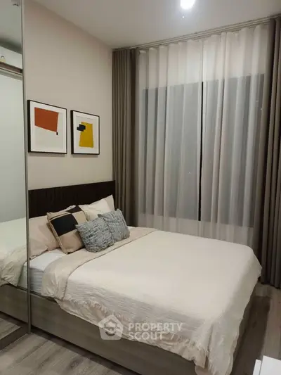 Modern bedroom with stylish decor and cozy ambiance, featuring elegant artwork and soft lighting.