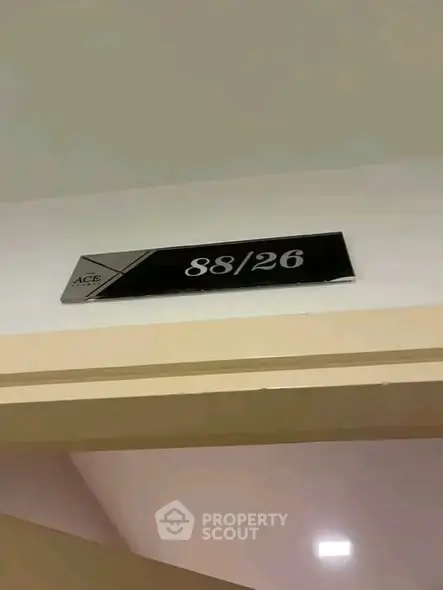 Modern apartment unit number sign on a hallway wall, indicating unit 88/26.