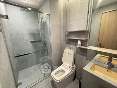 Modern bathroom with glass shower and sleek fixtures in contemporary home.