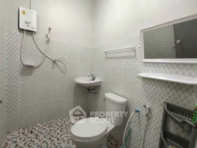 Compact bathroom with wall-mounted sink and shower in modern design.