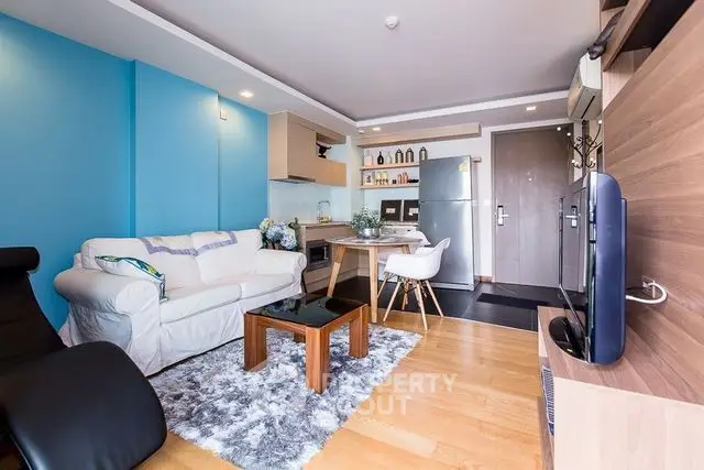 Modern living room with open kitchen, stylish decor, and cozy seating area.