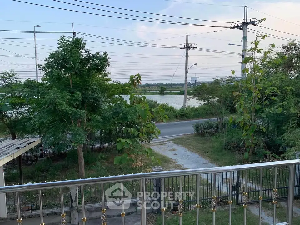 Scenic balcony view overlooking lush greenery and a serene river.