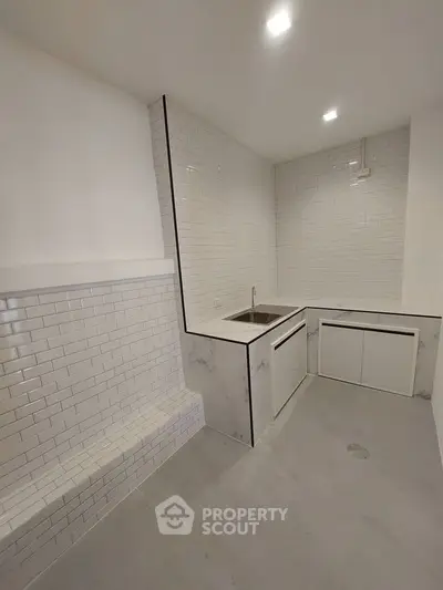 Modern minimalist kitchen with sleek white subway tiles and marble countertops.