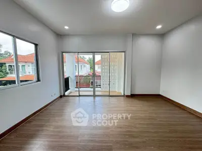 Spacious living room with large windows and balcony access in modern home.