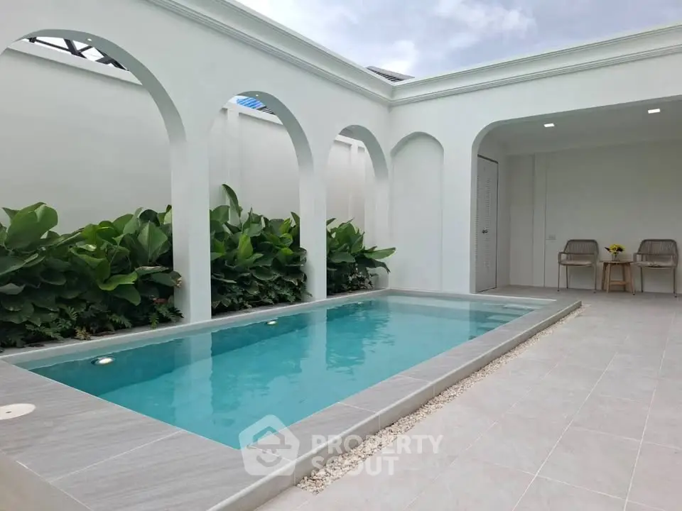 Luxurious private pool area with elegant arches and lush greenery