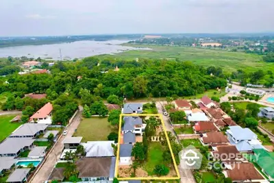 Aerial view of suburban homes with lush greenery and a nearby lake, showcasing serene living environment.