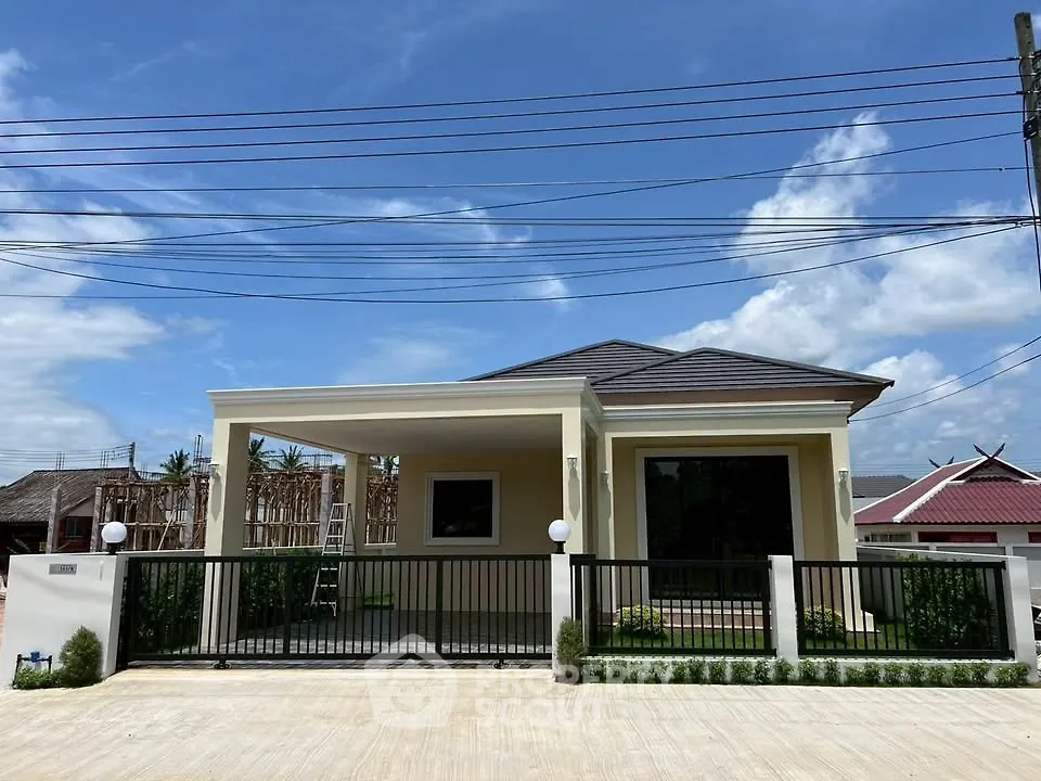 Charming single-story home with modern design and spacious driveway under clear blue skies.
