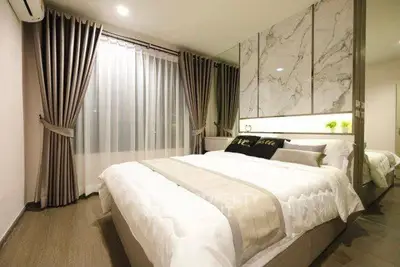 Luxurious bedroom with elegant decor and large window, featuring modern design and cozy ambiance.