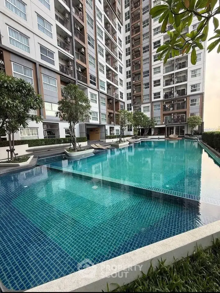Luxurious residential building with a stunning outdoor pool and lush greenery, perfect for relaxation.