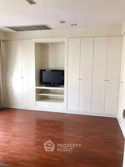 Spacious living room with built-in storage and hardwood floors