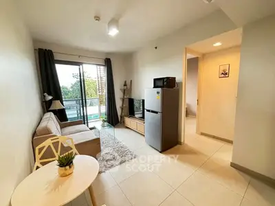 Modern living room with cozy sofa, TV, and large window offering a scenic view, perfect for relaxation.