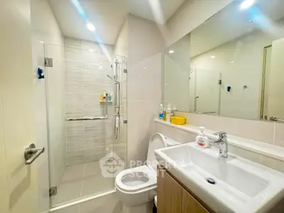 Modern bathroom with glass shower and sleek fixtures in a contemporary home.