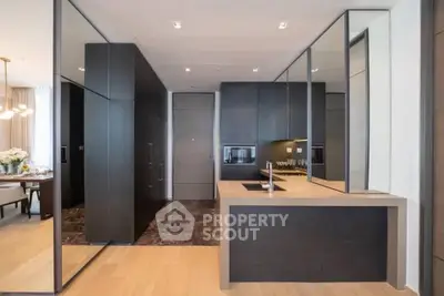 Luxurious modern kitchen with sleek cabinetry and open layout in upscale apartment.