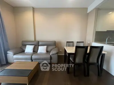 Modern living room with sleek furniture and dining area in open layout apartment.
