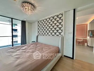 Luxurious bedroom with elegant chandelier and stylish wallpaper in modern apartment