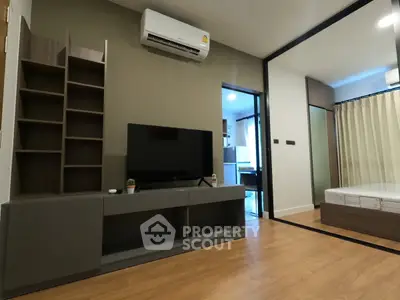 Modern living room with sleek TV unit and air conditioning, adjacent to a cozy bedroom.