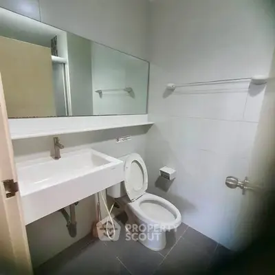 Modern bathroom with sleek fixtures and large mirror in a contemporary home.