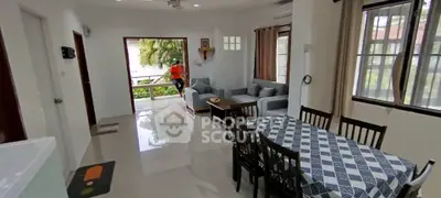 Spacious living and dining area with modern furniture and large windows for natural light.