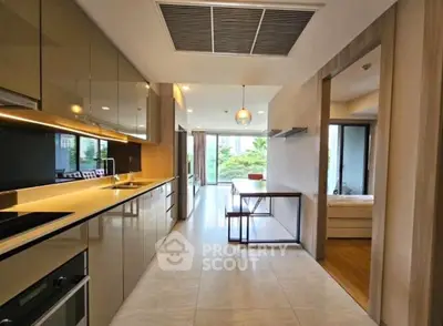 Modern kitchen with sleek cabinetry and open layout leading to dining area and balcony view.