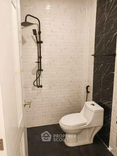 Modern bathroom with sleek black shower and white brick tiles
