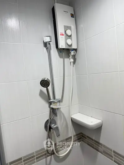 Modern bathroom with sleek shower and water heater, featuring elegant tile design.