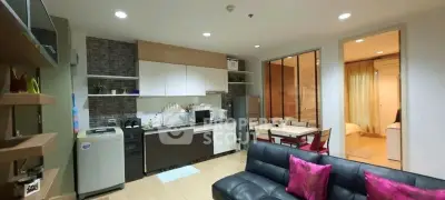 Modern open-layout living room and kitchen with stylish decor and cozy ambiance.
