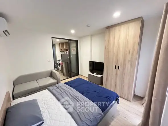 Modern bedroom with cozy bed, sofa, and wardrobe in a stylish apartment.