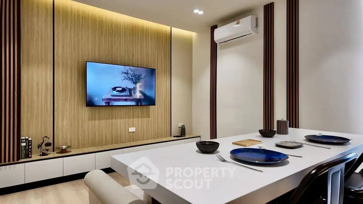 Modern dining area with sleek design and wall-mounted TV, perfect for stylish living.