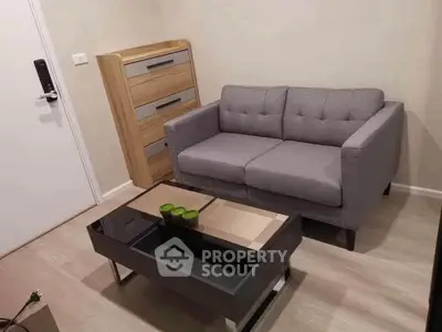 Cozy living room with modern gray sofa and stylish coffee table in a compact apartment.