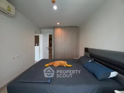 Modern bedroom with stylish decor and ample natural light, featuring a comfortable bed and sleek wardrobe.