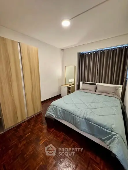 Cozy bedroom with wooden flooring and modern furnishings