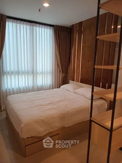 Modern bedroom with wooden accents and natural light through large window.