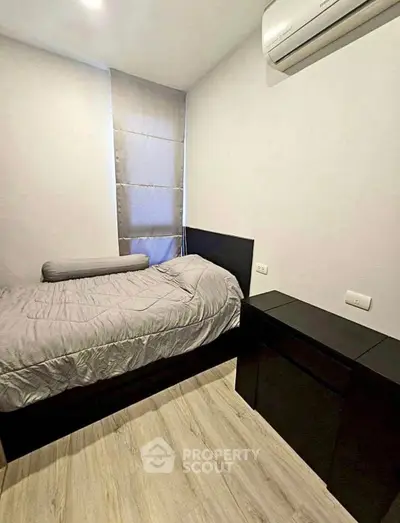 Cozy minimalist bedroom with air conditioning and modern furnishings.