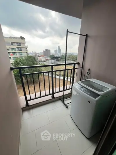 Compact balcony with washing machine and city view, ideal for urban living.
