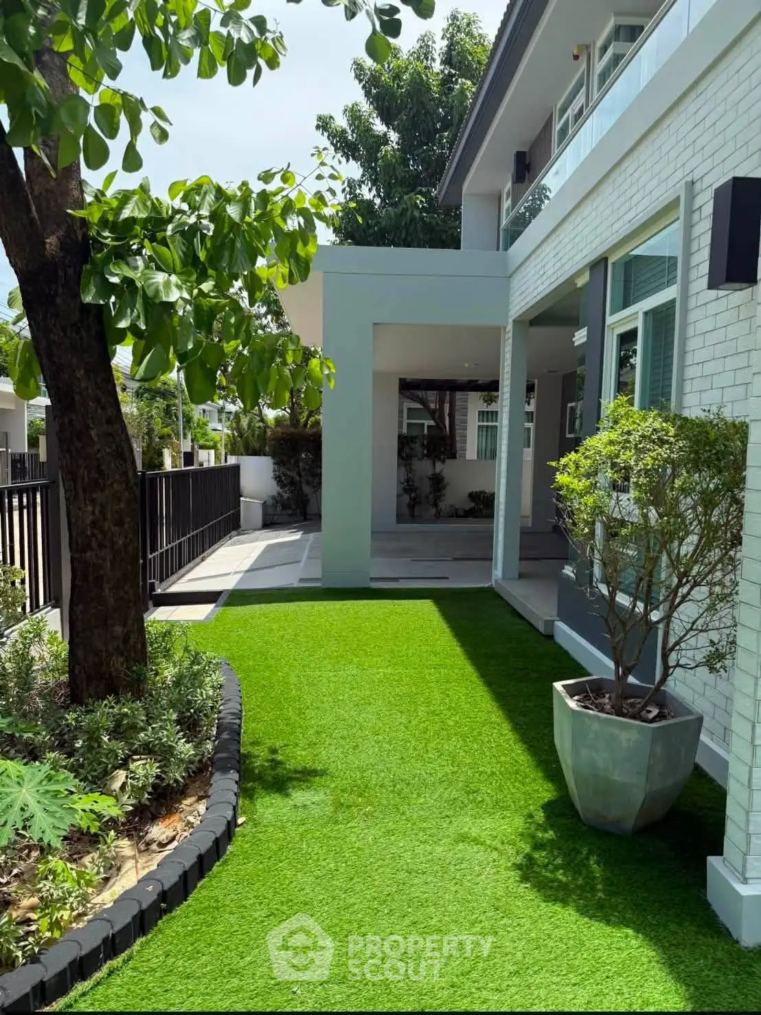 Charming modern home with lush green garden and spacious outdoor area, perfect for relaxation and entertaining.