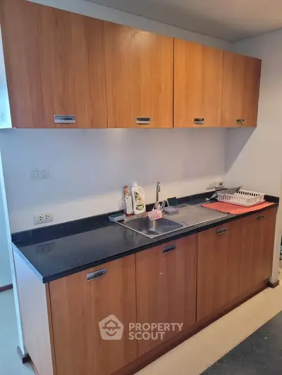 Modern kitchen with wooden cabinets and sleek countertop in a stylish apartment.