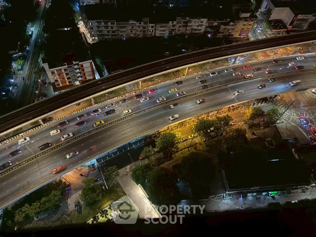 Stunning aerial view of a bustling city highway at night, showcasing vibrant urban life.