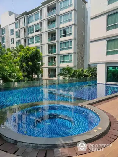 Luxurious apartment complex with stunning pool and modern architecture.