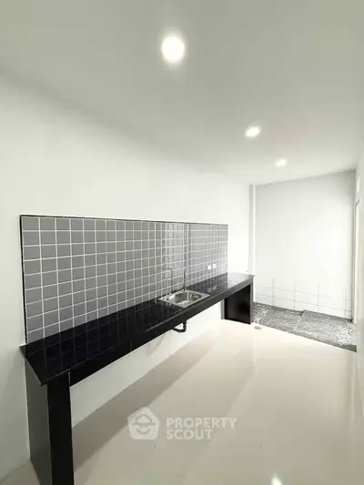 Modern kitchen with sleek black countertop and stylish backsplash tiles