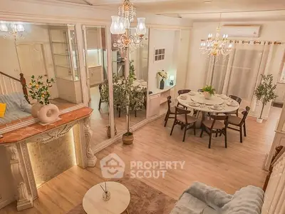 Elegant living room with dining area, featuring chandeliers and classic decor, perfect for stylish gatherings.