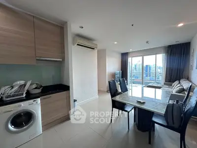 Spacious open-plan living room with modern kitchen and city view balcony.