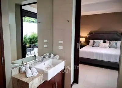 Luxurious bedroom with ensuite bathroom and garden view, perfect for modern living.