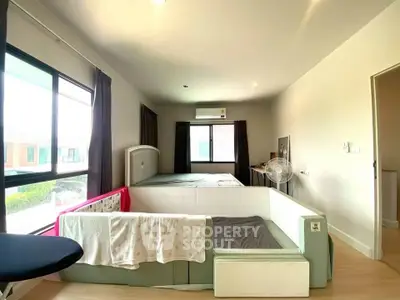 Spacious bedroom with modern design and large windows for natural light.