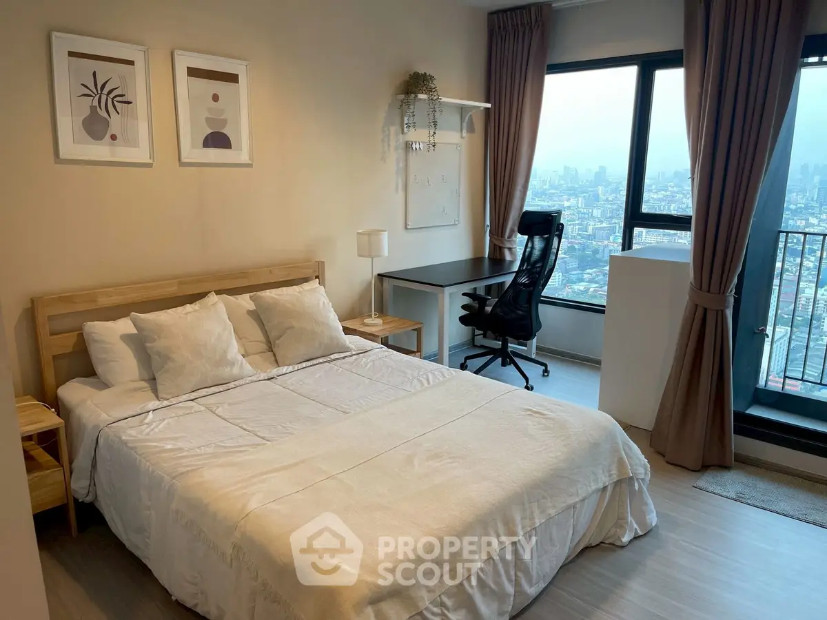 Modern bedroom with city view, featuring cozy bed, stylish decor, and a workspace by the window.