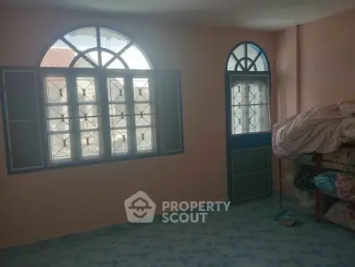 Spacious room with arched windows and tiled floor, perfect for customization.