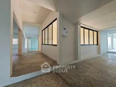 Spacious modern interior with large windows and open layout, ideal for versatile living or office space.