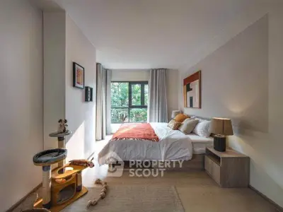 Spacious bedroom with large window and modern decor, featuring a cozy bed and stylish furnishings.