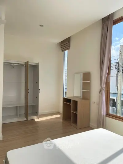 Bright bedroom with large windows and modern furniture in a stylish apartment.