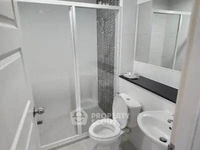 Modern bathroom with glass shower enclosure and sleek fixtures